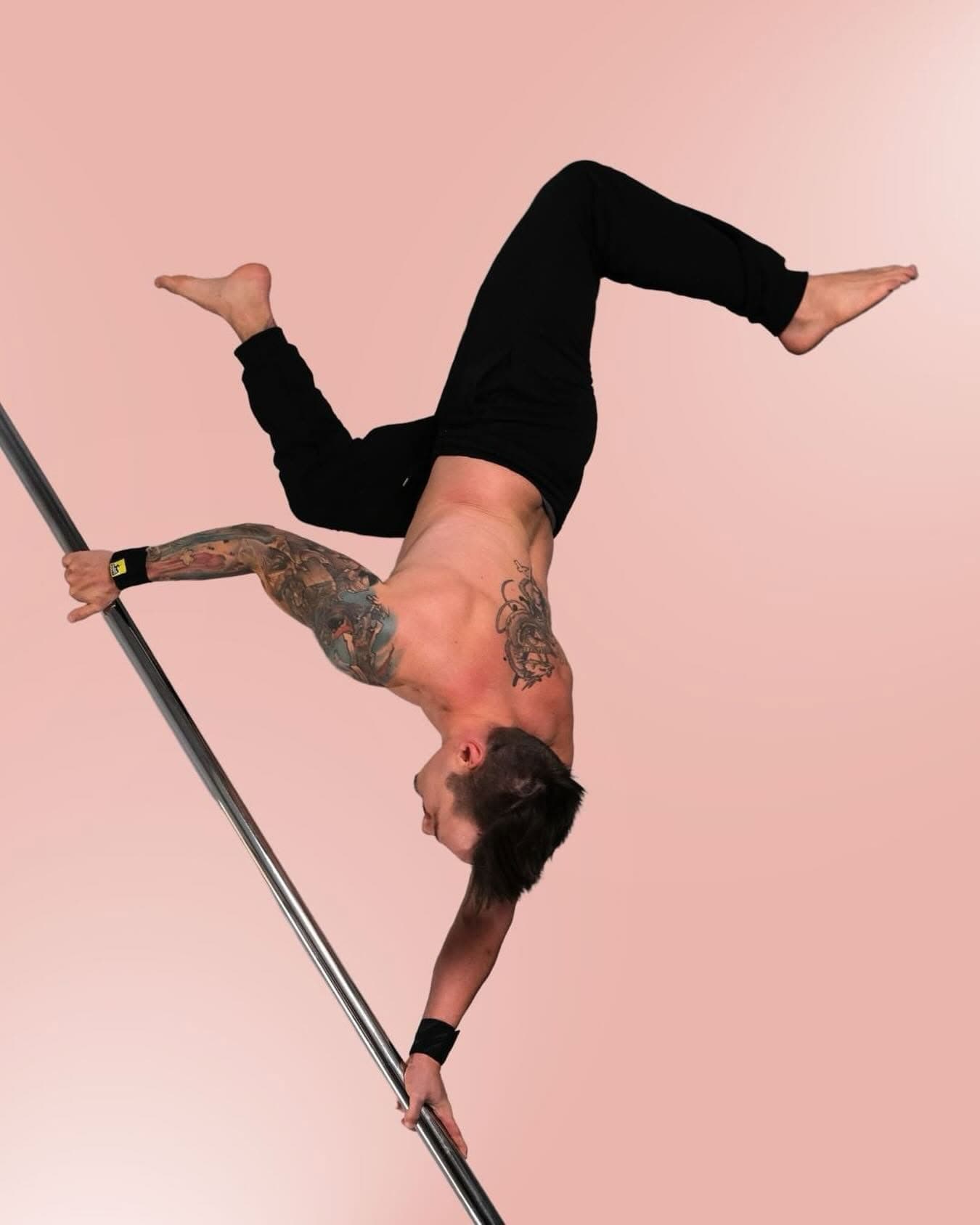 Pole athlete inverted on the pole wearing SneakyDeez wrist wraps