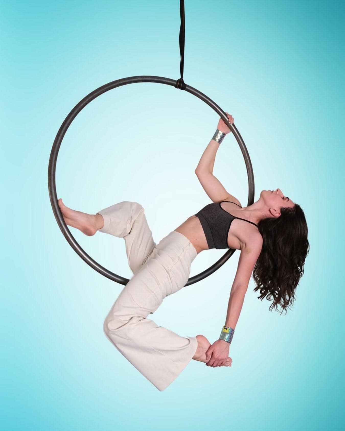 Aerial hoop artist posing in the hoop wearing SneakyDeez wrist wraps